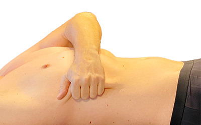 Bild eines Mannes, der eine Hautfalte an seinem Oberkörper zusammenzieht: Boeger Therapie - Faszien- und Narbentherapie in Zürich Volketswil